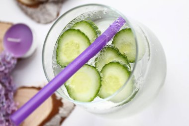 Lila ve ahşap dekorasyon beyaz zemin üzerine salatalık ile aromalı su detoks. Sağlıklı gıda kavramı. Yaz ev yapımı kokteyl serinletici. Uzay kopyalayın. Hiçbir keskinleştirme. 