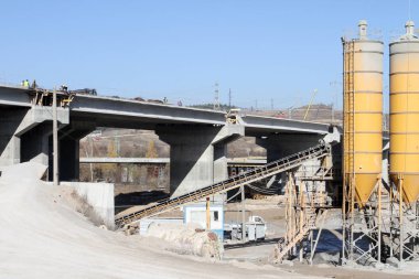 Yeni otoyol yapım aşamasında. Yeni bir köprü otoyol büyük şehir trafiğini geçirecek şekilde beton ve metal yapılmış. Bitmemiş bir eyaletler arası köprü. Yol yapım aşamasında. Vinçler ve beton mikser ile devam eden yol uygulama projesi. 