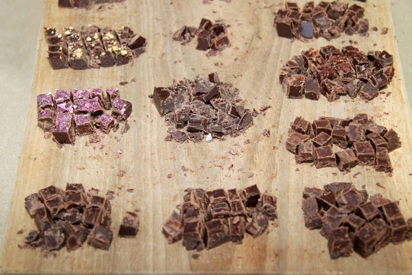 नट के साथ कच्चे चॉकलेट के टुकड़े। लकड़ी की पीठ पर प्राकृतिक चॉकलेट — स्टॉक फ़ोटो, इमेज