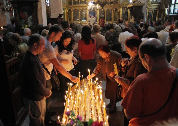 Люди зажигают свечи в церкви Святого Георгия во время большого праздника — стоковое фото