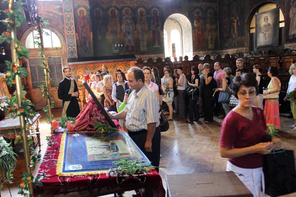 Procession of people wait to kiss icon in church on big holiday — Stockfoto