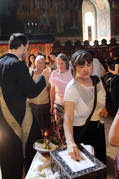 Женщина дает пожертвования церкви после того, как была помазана — стоковое фото