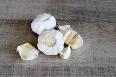 Sarımsak soğanlarını ve ahşap arka planda sarımsak karanfillerini kapat..