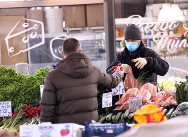 COVID-19 'dan korunmak için maske takan insanlar, 17 Mart 2020' de Bulgaristan 'ın Sofya kentindeki pazarda sebze ve meyve alışverişi yapıyorlar..