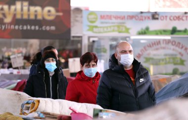 COVID-19 'dan korunmak için maske takan insanlar, 17 Mart 2020' de Bulgaristan 'ın Sofya kentindeki pazarda sebze ve meyve alışverişi yapıyorlar..