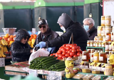 COVID-19 'dan korunmak için maske takan insanlar, 17 Mart 2020' de Bulgaristan 'ın Sofya kentindeki pazarda sebze ve meyve alışverişi yapıyorlar..