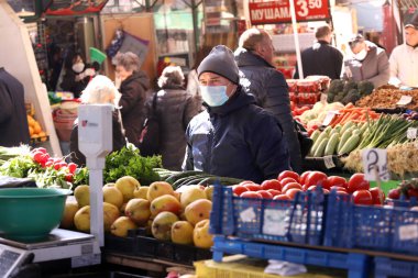 COVID-19 'dan korunmak için maske takan insanlar, 17 Mart 2020' de Bulgaristan 'ın Sofya kentindeki pazarda sebze ve meyve alışverişi yapıyorlar..