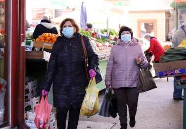 COVID-19 'dan korunmak için maske takan insanlar, 17 Mart 2020' de Bulgaristan 'ın Sofya kentindeki pazarda sebze ve meyve alışverişi yapıyorlar..