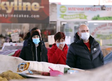 COVID-19 'dan korunmak için maske takan insanlar, 17 Mart 2020' de Bulgaristan 'ın Sofya kentindeki pazarda sebze ve meyve alışverişi yapıyorlar..
