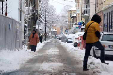 Bulgaristan 'ın başkenti Sofya' da 24 Mart 2020 'de meydana gelen kar fırtınası sonrasında, insanlar temizlenmemiş caddelerde kar üzerinde yürüyorlar.