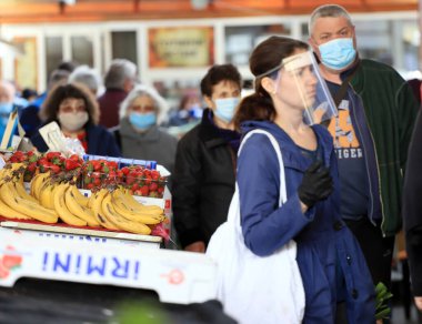 Bulgaristan 'ın Sofya kentindeki bir pazar yerinde, koronavirüs COVID-19' un önlenmesi için maske ve eldiven takan insanlar 04 / 14 / 2020.