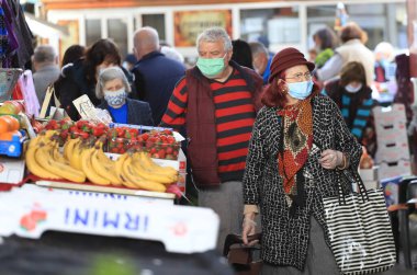 Bulgaristan 'ın Sofya kentindeki bir pazar yerinde, koronavirüs COVID-19' un önlenmesi için maske ve eldiven takan insanlar 04 / 14 / 2020.