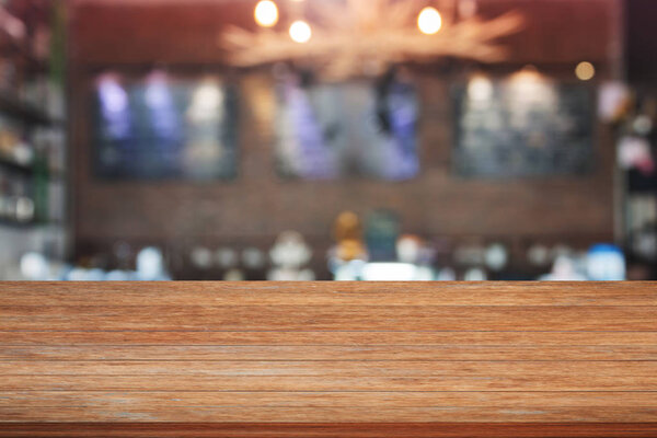 Brown wooden table top with blurred cafe background