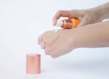Beyaz arka plan üzerinde izole kozmetik şişe tutan kadın el