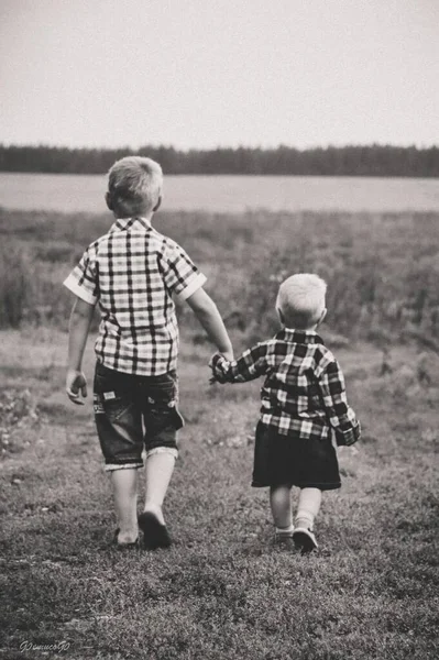 two boys are walking along the path