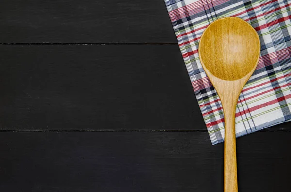 Wooden spoon over tablecloth — Stock Photo, Image