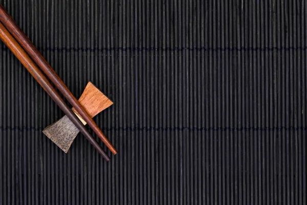 Wooden chopsticks on black — Stock Photo, Image