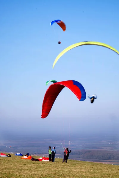 滑翔伞在晴朗的蓝天中飞行 名滑翔伞在地面上即将起飞 红色和黄色降落伞 — 图库照片