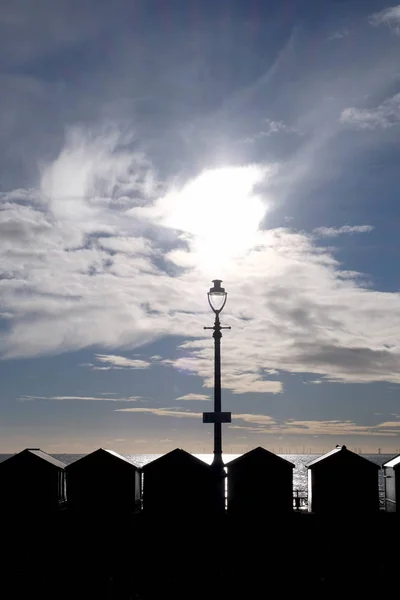 Una Línea Cabañas Playa Una Lámpara Calle Silhoutted Negro Por —  Fotos de Stock