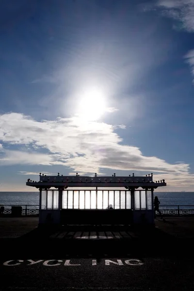 Brightons Strandpromenaden Förgrunden Leder Till Sittplats Skydd Solen Låg Himlen — Stockfoto