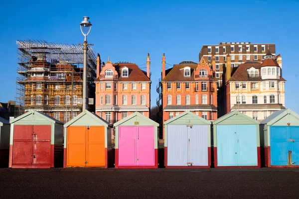 Una línea de 7 cabañas de playa multicolores en el paseo marítimo de Brighton — Foto de Stock