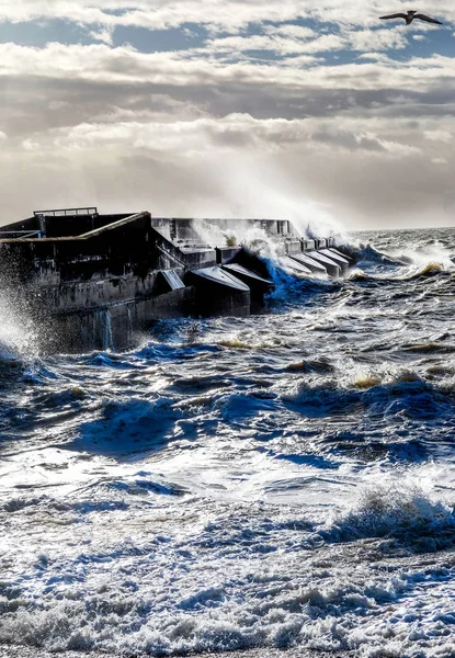 rough seas crashing against Brighton marina habour wall, a solit