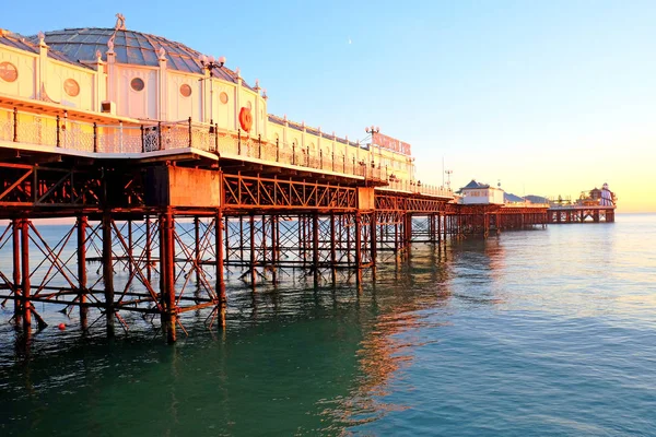 Brighton Pier ragt bei Sonnenuntergang über das Meer hinaus — Stockfoto