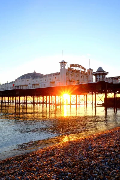 Brighton Palace Pier glödande gul med solnedgången under — Stockfoto