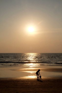 Tanımlanamayan küçük bir çocuğun silueti bir ayak tabancasını kaldırıyor.