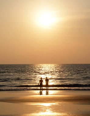 Tanımlanamayan genç bir çiftin silueti yan yana duruyor.