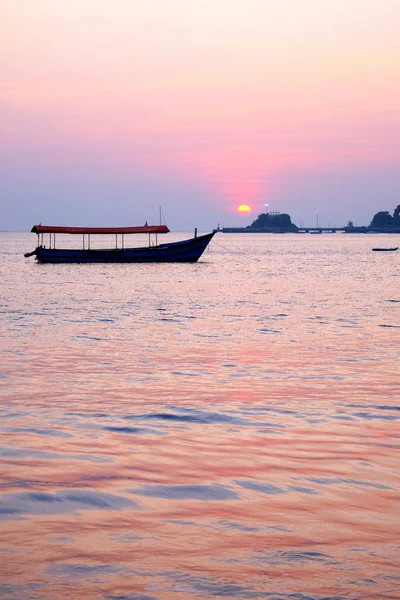 一艘捕鱼船落日，在多娜 · 宝拉 · 巴上空投射出粉色光芒 — 图库照片