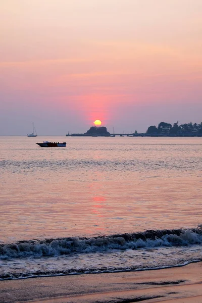 一艘快艇落日，在多娜宝拉湾上空投射出粉色光芒, — 图库照片