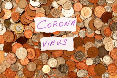 Yüzlerce gümüş ve bakır madeni paranın üzerinde duran iki parça yırtık kağıda mor mürekkeple yazılmış Corona virüsü sözcüğü, İngiliz parasının sterlini, korona virüsü salgınını ve parayı sembolize ediyor.