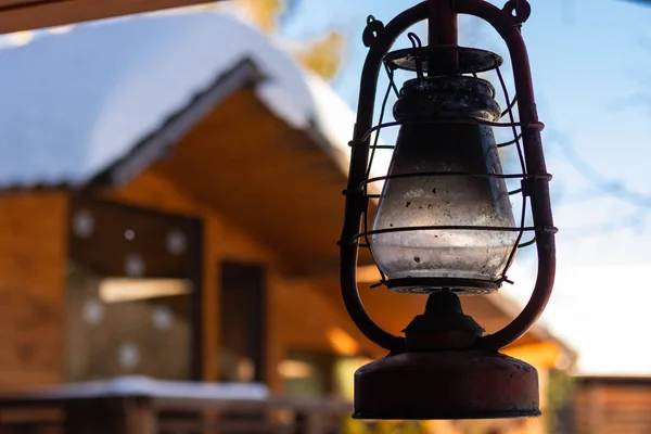Verandadaki evin yanında bir sokak gazyağı lambası. Güneşli bir günde, ama kış.