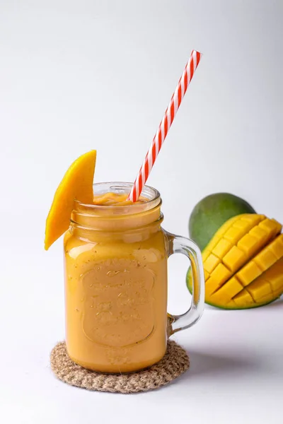 Tropische smoothie gemaakt van mango op een witte achtergrond, verticale oriëntatie — Stockfoto