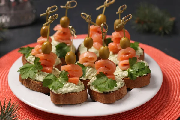 Закуска на святковому столі - канапе з лососем, вершковим сиром, оливками та авокадо — стокове фото
