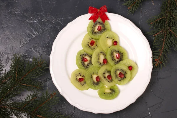 Arbre de Noël fait de kiwi et grenade, idée créative pour Noël et Nouvel An plats de fête, collation aux fruits pour les enfants — Photo