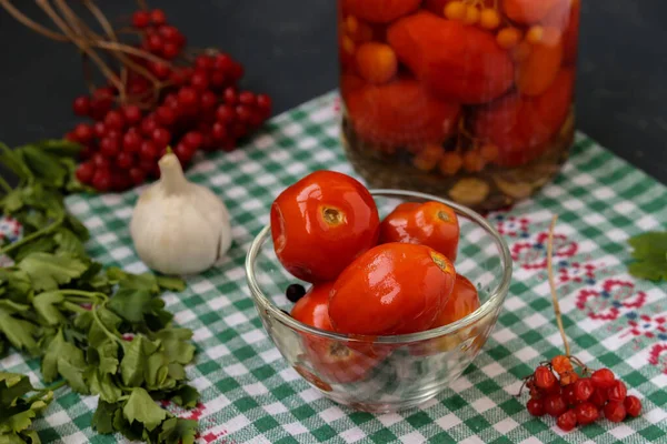 Homemade salted tomatoes in glass bowl and jar on a dark background, Fermented food — Stock Photo, Image