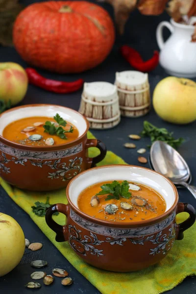 Soupe à la crème de citrouille dans des pots sur un fond sombre — Photo