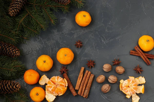 Composição de Ano Novo com tangerinas, anis, nozes, paus de canela e ramos de abeto verdes em um fundo escuro, orientação horizontal — Fotografia de Stock