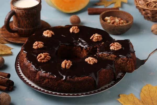 Kotitekoinen kurpitsa muffini koristeltu suklaa kuorrutus ja saksanpähkinät vaaleansininen tausta, vaakasuora suuntautuminen — kuvapankkivalokuva