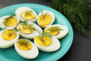 Koyu arka planda dereotlu leziz haşlanmış yumurtalar sağlıklı beslenme, yatay yönelim.