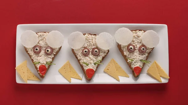 Sandvișuri amuzante pentru copii în formă de soți drăguți cu brânză, ouă și bețe de crab pe fundal roșu, idee de artă alimentară, Vedere de sus — Fotografie, imagine de stoc