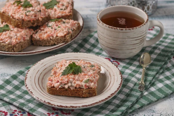 Домашние сэндвичи с крабовыми палочками, сыром и морковью на тарелке на клетчатой скатерти, горизонтальная ориентация — стоковое фото