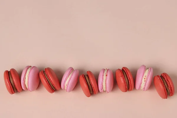 Biscoitos doces saborosos, macaroons vermelhos e rosa em um fundo rosa, orientação horizontal, espaço de cópia — Fotografia de Stock