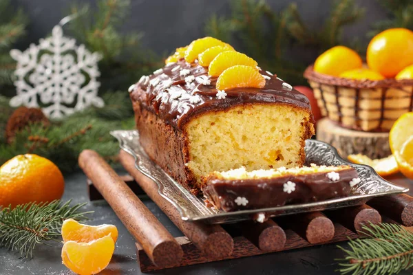 Cupcake with tangerines, covered with chocolate glaze is located on the New Year's background, Festive still life — Stock Photo, Image