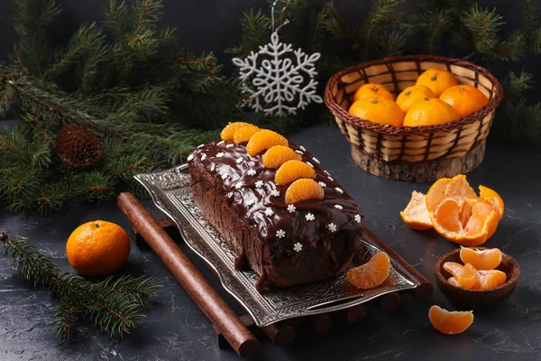 Кекс с мандаринами, покрытые шоколадной глазурью расположен на фоне Нового года, праздничный натюрморт — стоковое фото