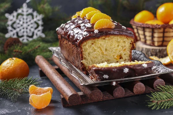 Cupcake with tangerines, covered with chocolate glaze is located on the New Year's background, Festive still life — Stock Photo, Image