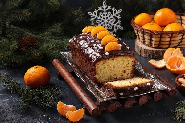Кекс с мандаринами, покрытые шоколадной глазурью расположен на фоне Нового года, праздничный натюрморт — стоковое фото