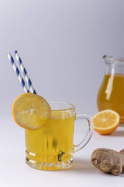 Beyaz arka planda limon, zencefil, bal ve zerdeçal ile ev yapımı canlandırıcı içecek, dikey yönelim